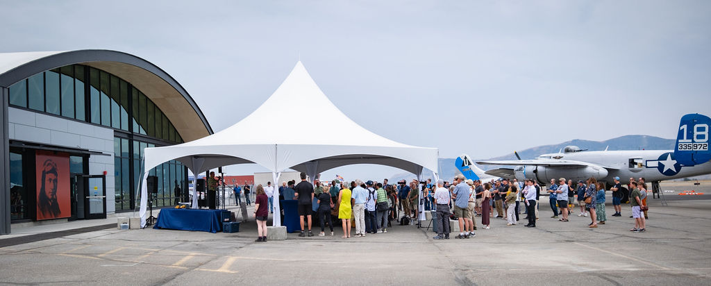 Corporate event stage with speakers and presentation screen inside a tent in Eastern Washington