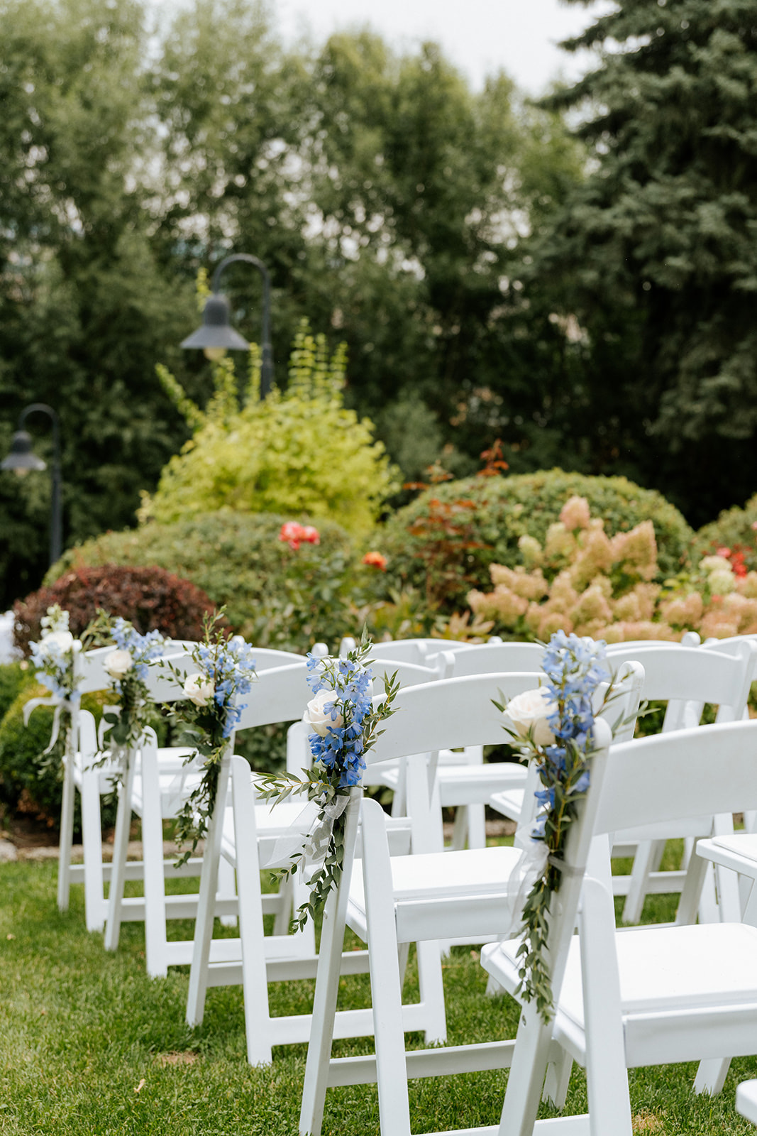 Ceremony chair rentals lining an aisle with blue floral decor in Eastern Washington