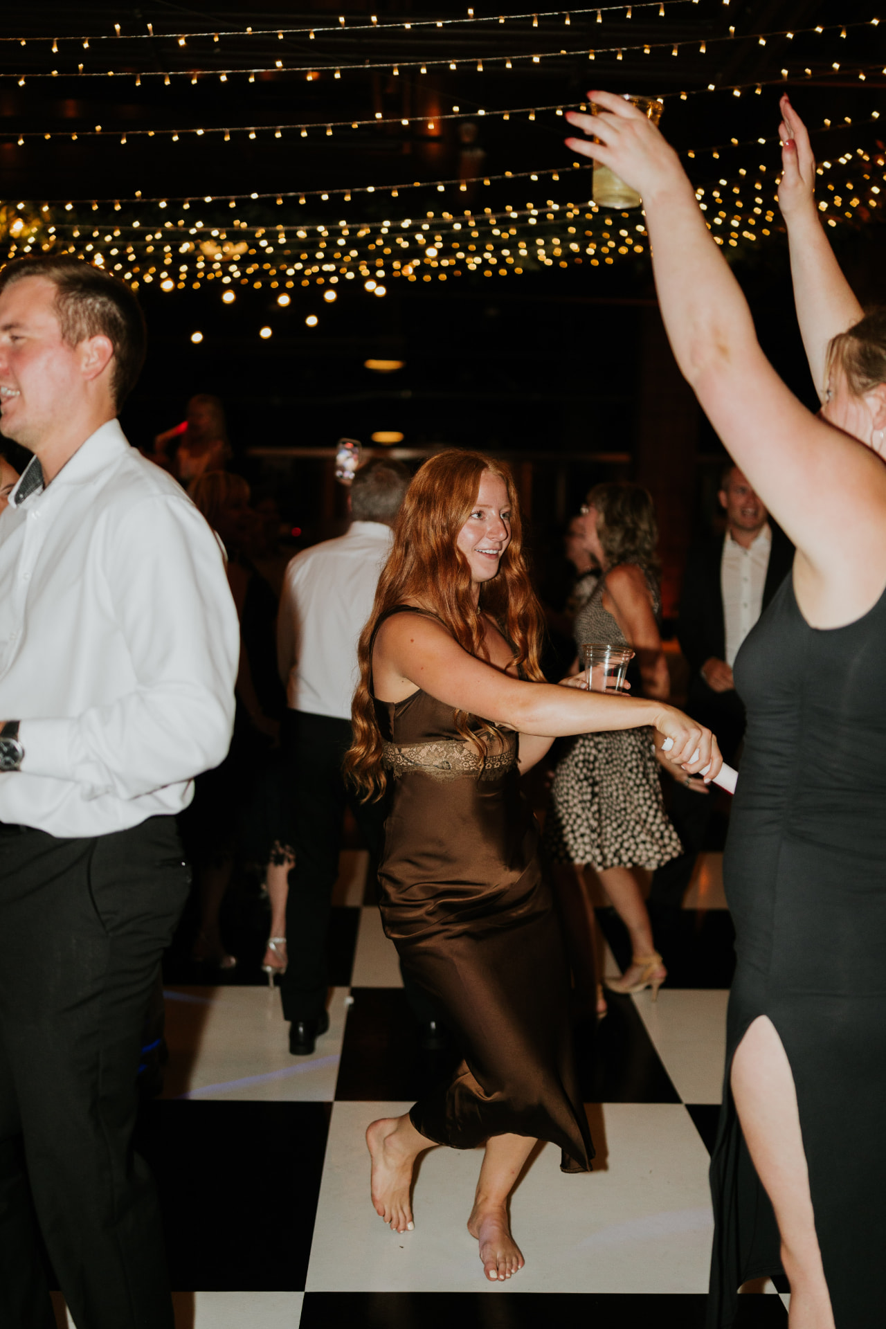 Guests dancing on a black and white checkered dance floor rental at Swiftwater Cellars in Cle Elum, Washington