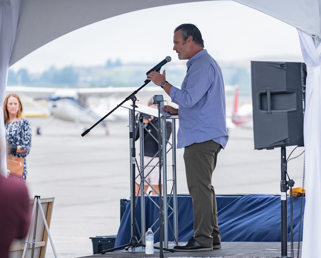 Seated audience under a tent rental during a corporate presentation in Eastern Washington