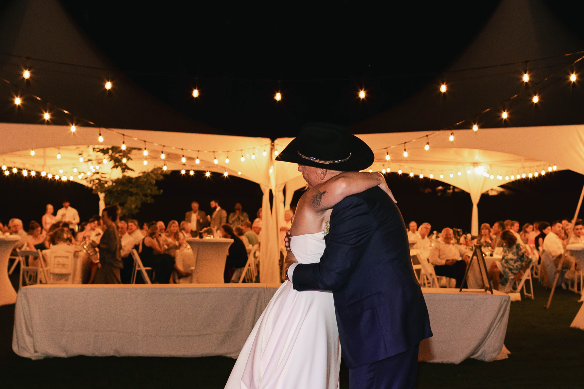 Parent dance under string lights on a rented dance floor at an Eastern Washington wedding