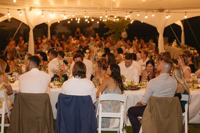 Warm bistro string lighting installed inside a marquee tent