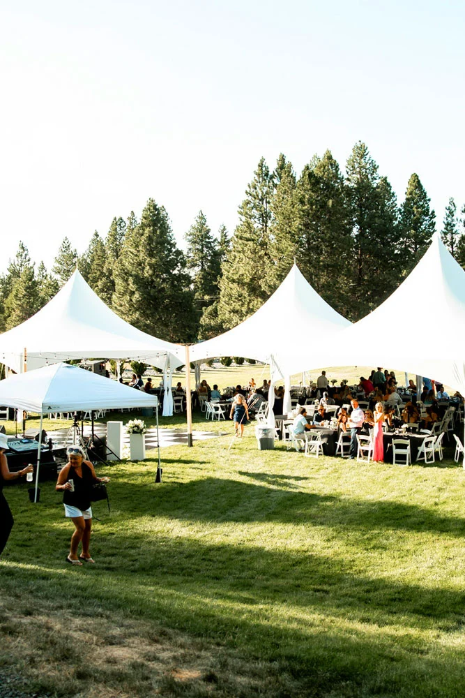 Large white marquee tent set up on a grassy lawn with guest seating for an outdoor event in Eastern Washington