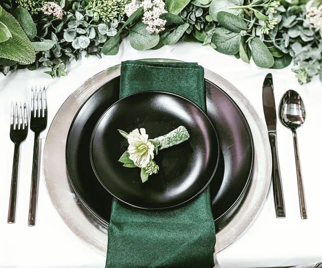 Place setting with charger plate, matte black plate and emerald napkin rentals in Eastern Washington
